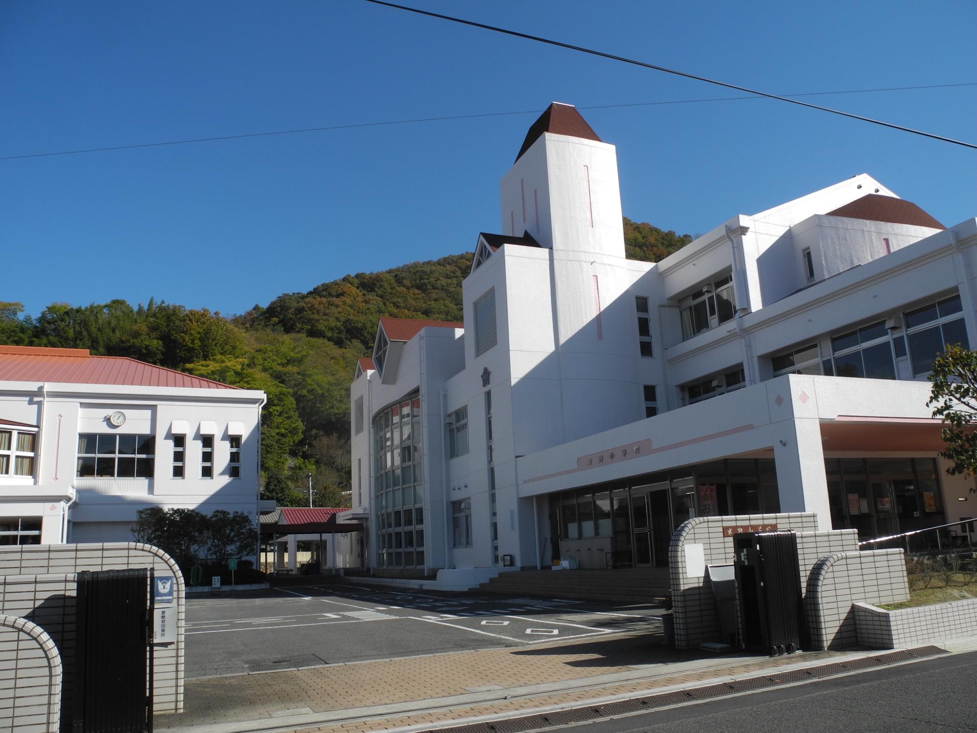 白とピンクで統一された東野小学校の校舎の全体外観写真