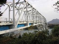橋の上部は白い骨組みで橋げた部分が青い長島大橋の写真